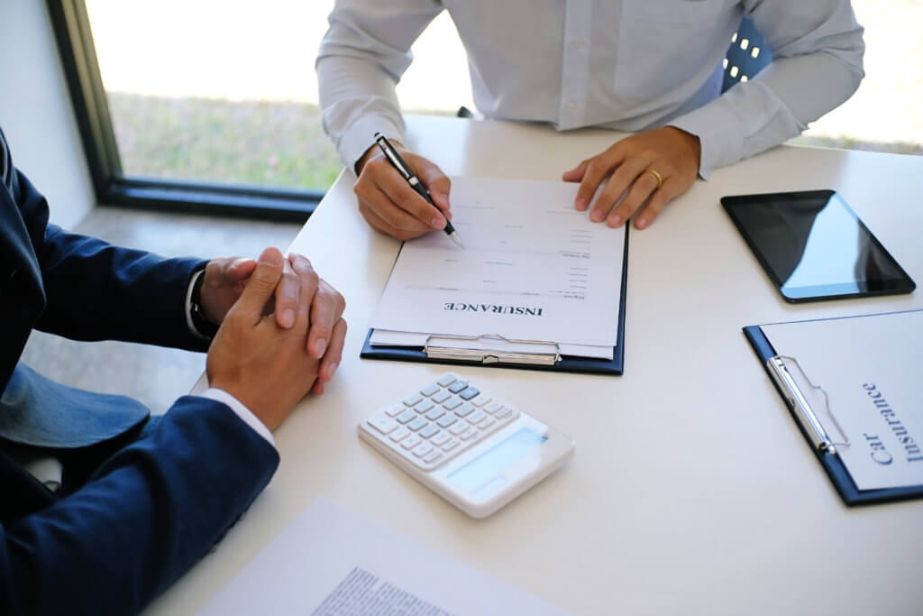 Sales manager giving advice application form document, considering mortgage loan offer for car insurance