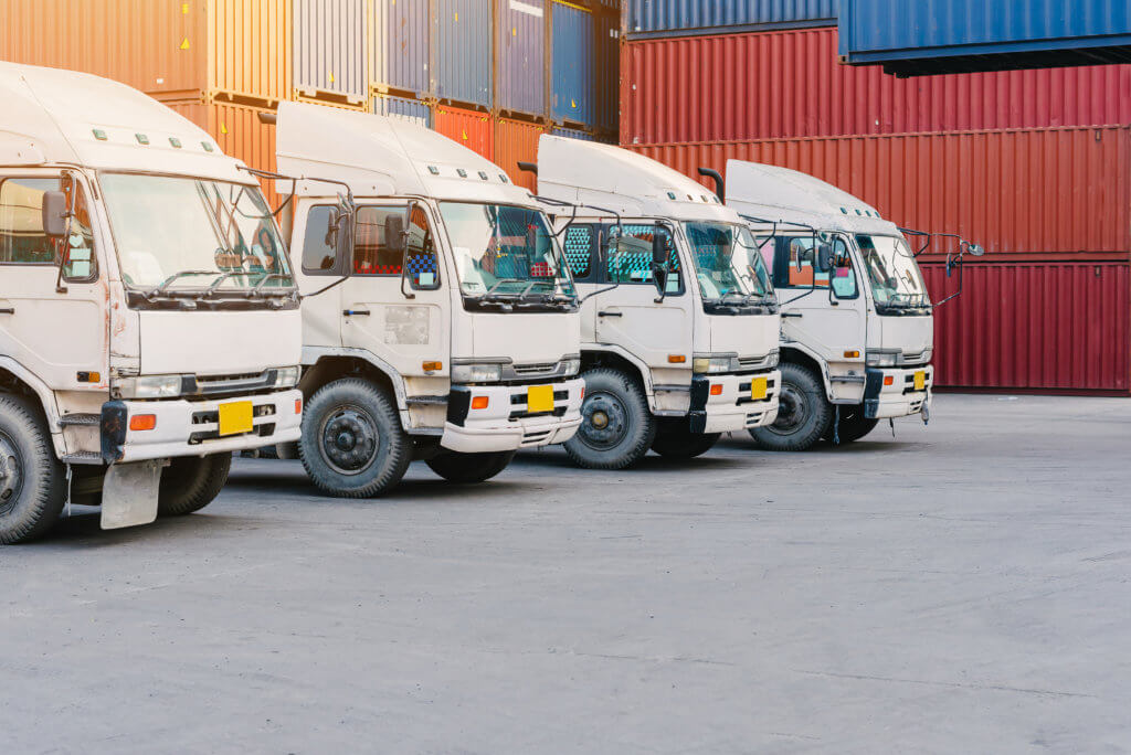 Line of cargo truck with container box for export import shipping at yard. transport concept