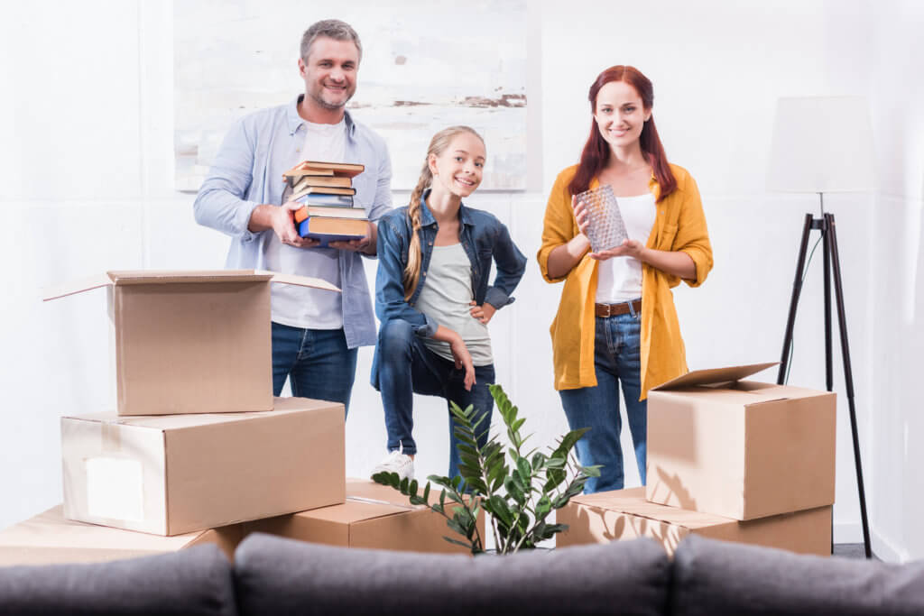 portrait of smiling family looking at camera at new home