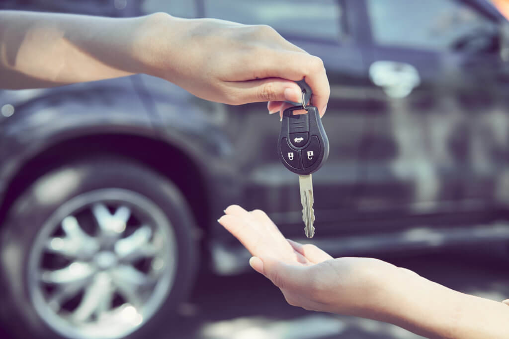 Woman's hand give the car key, rent a car concept