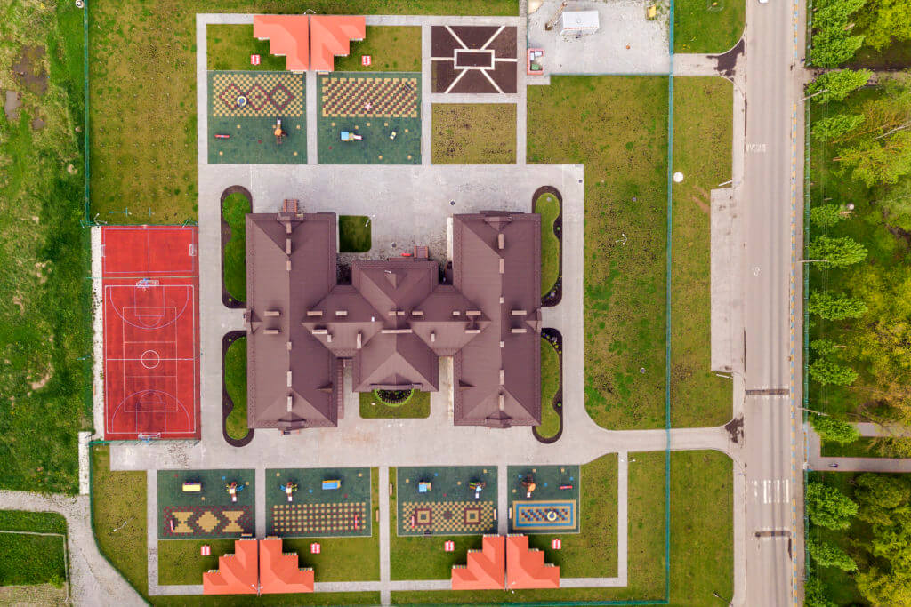 Top aerial view of new prescool building and yard with alcoves and green lawns.